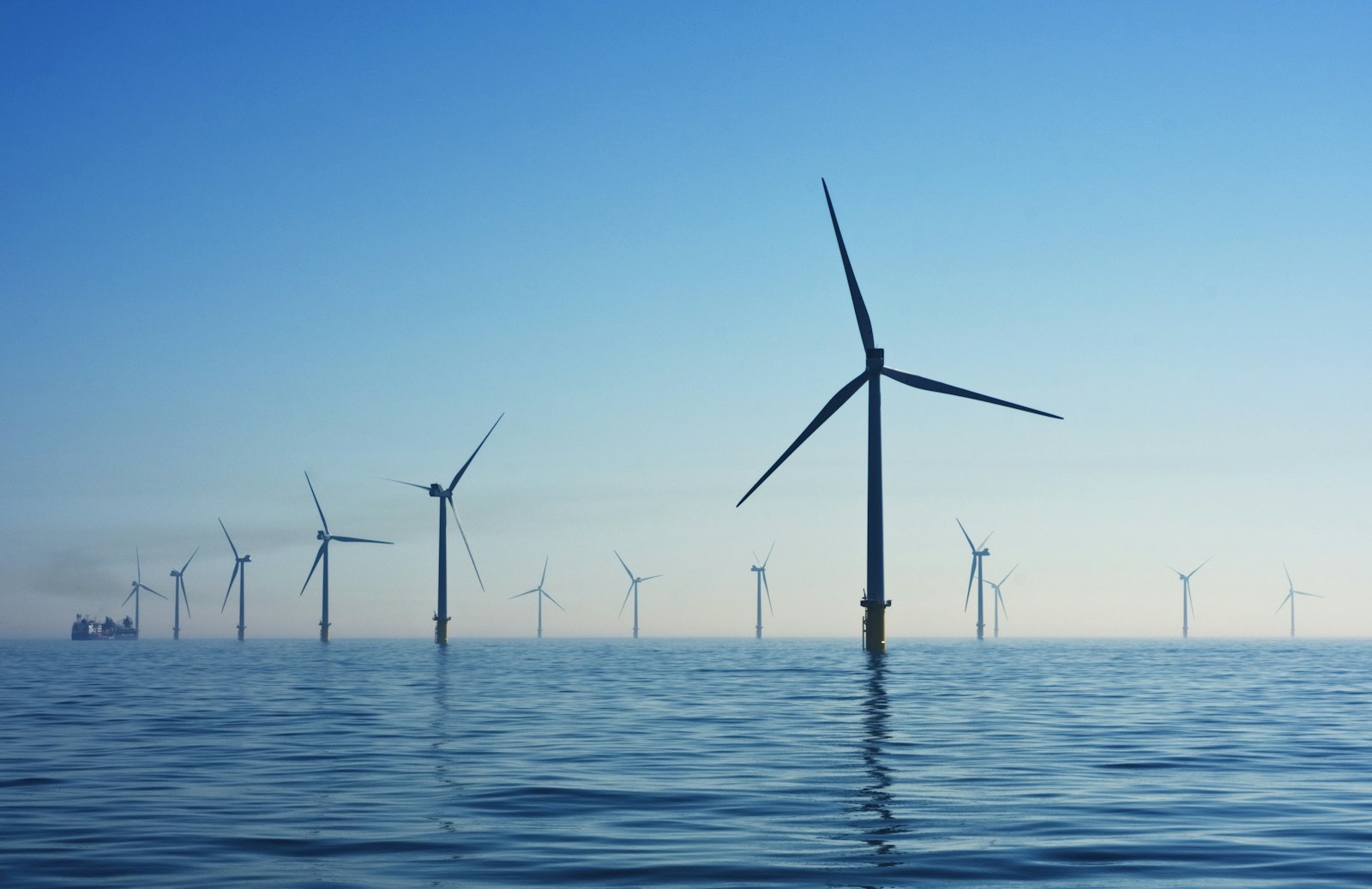 Offshore wind turbines in open water under a clear sky